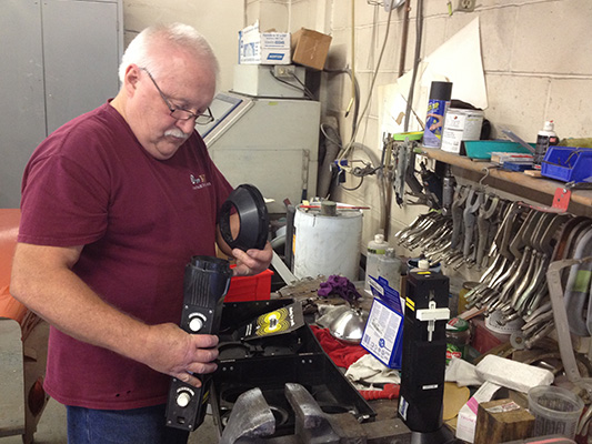Mechanic Jim Higgins gets ready to use the headlight adjuster.