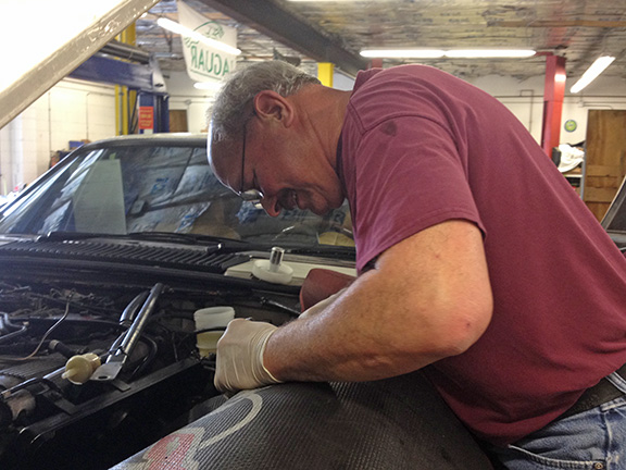 Shop foreman Ray Blaisse sorts out a problem in an engine bay.